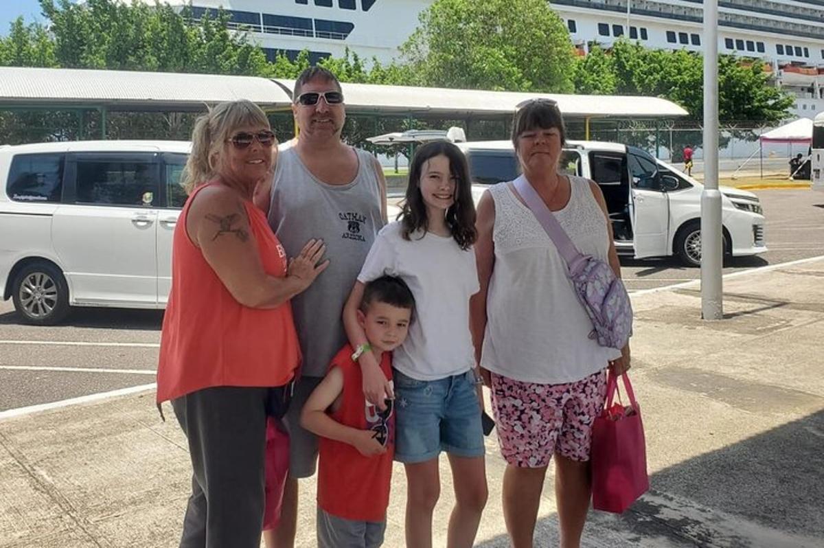 en familie som poserer for et bilde på en parkeringsplass