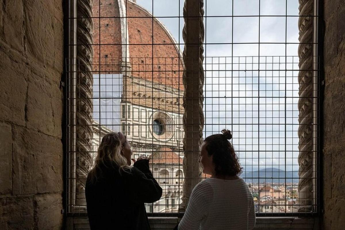 zwei Frauen schauen aus einem Fenster auf eine Kirche