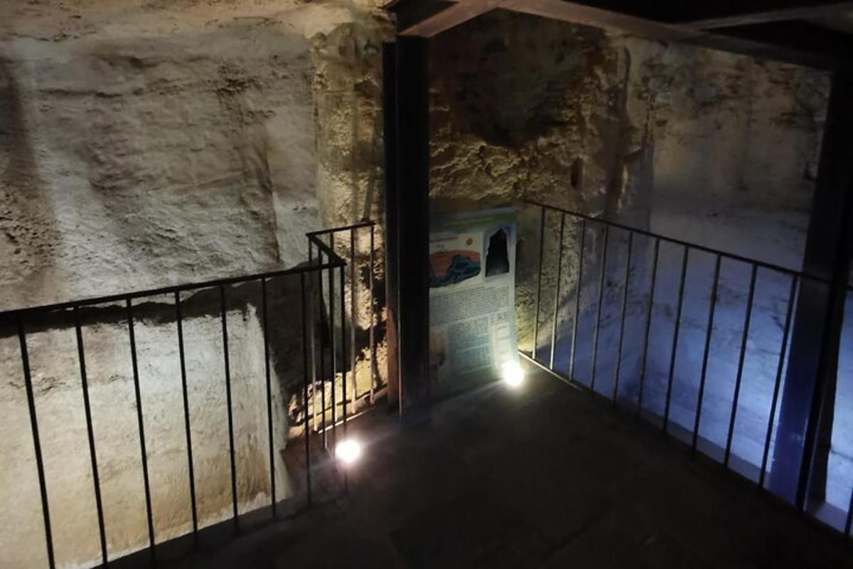 uma escada em uma caverna com um portão e luzes