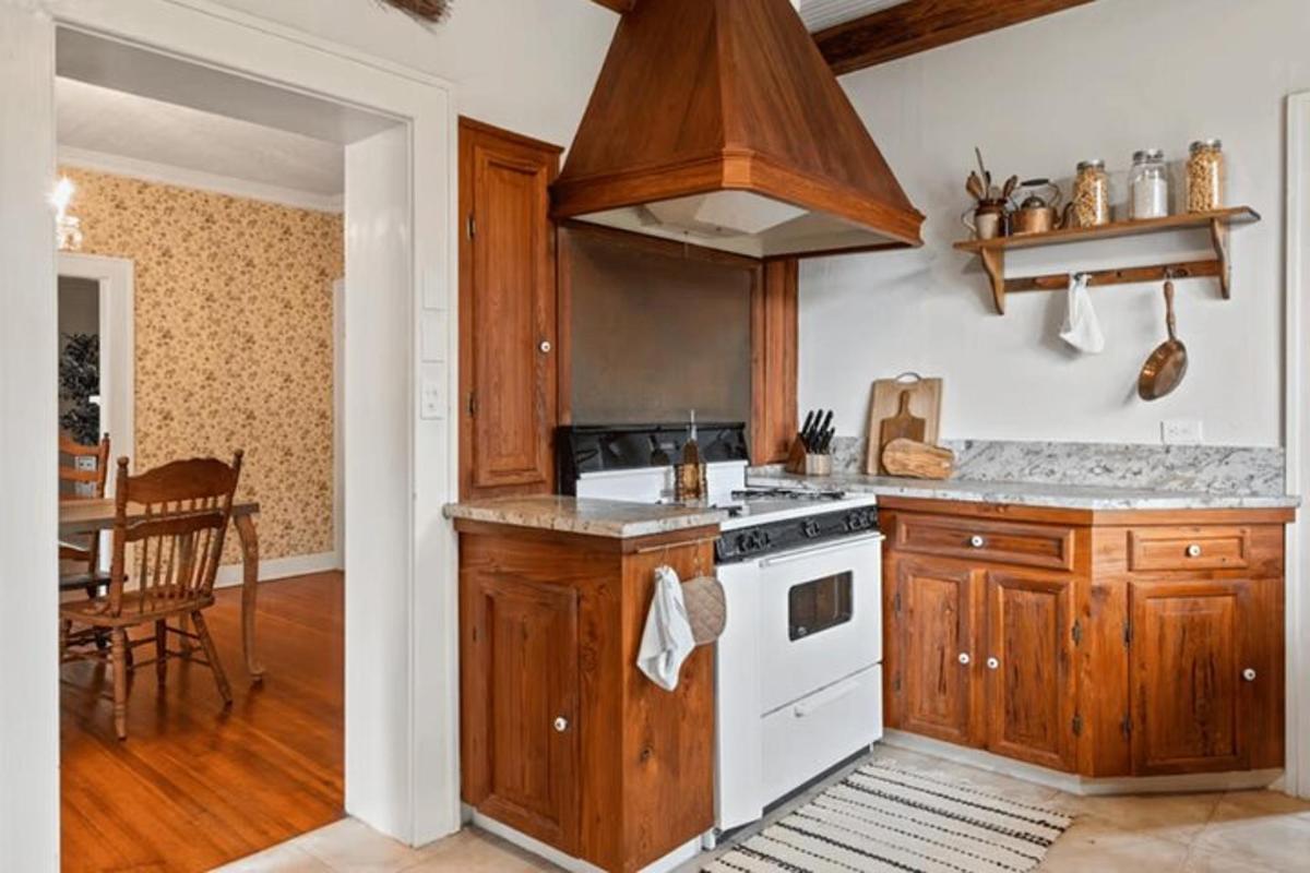 a kitchen with wooden cabinets and a white stove top oven