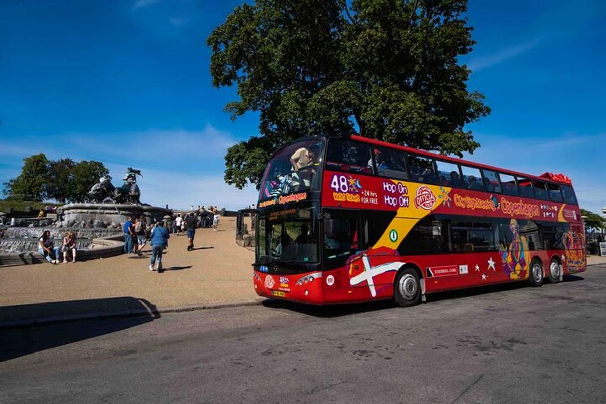 en rød dobbeltdekkerbuss som kjører nedover en gate