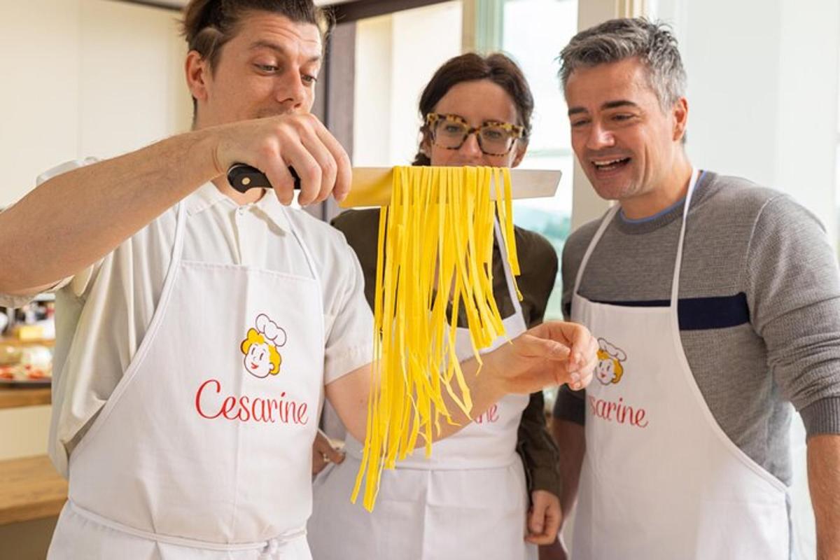 a man and a woman in a kitchen preparing spaghetti