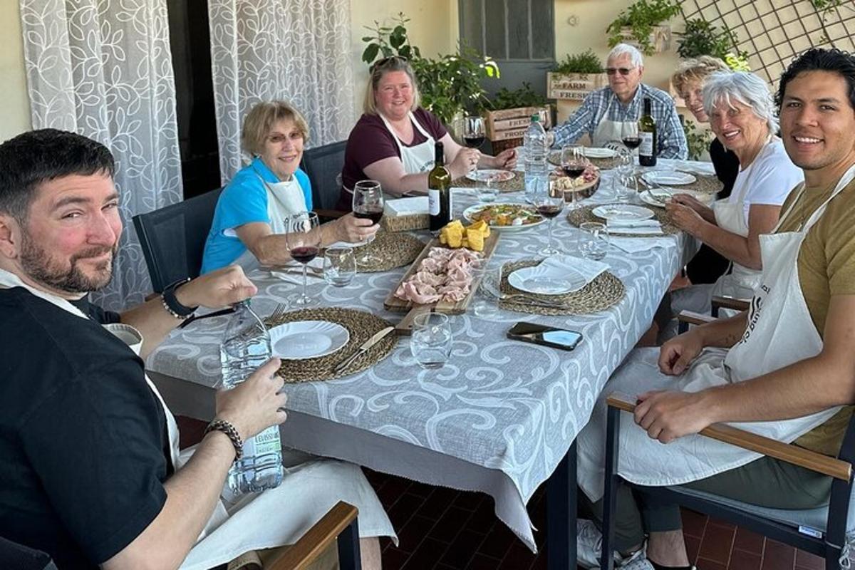 un gruppo di persone sedute attorno a un tavolo con bicchieri di vino