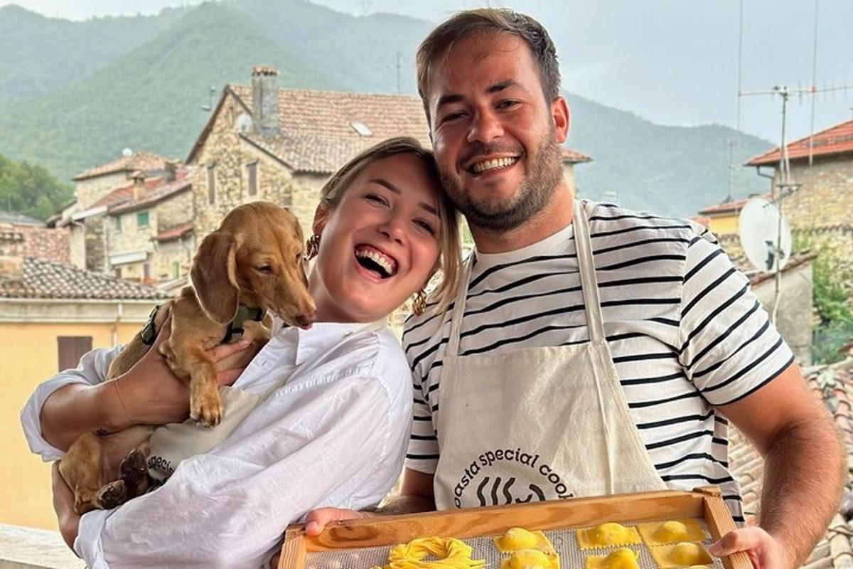 un uomo e una donna che tengono in braccio un cane in una scatola
