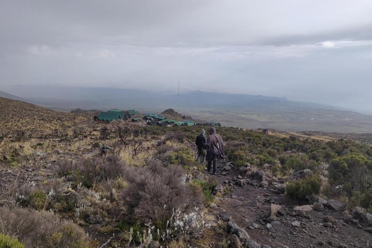 dues persones caminant per un turó al desert