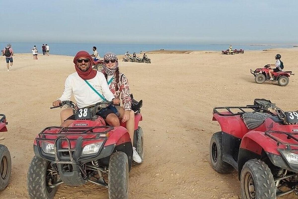 Dos personas viajan en vehículos todo terreno por la playa.