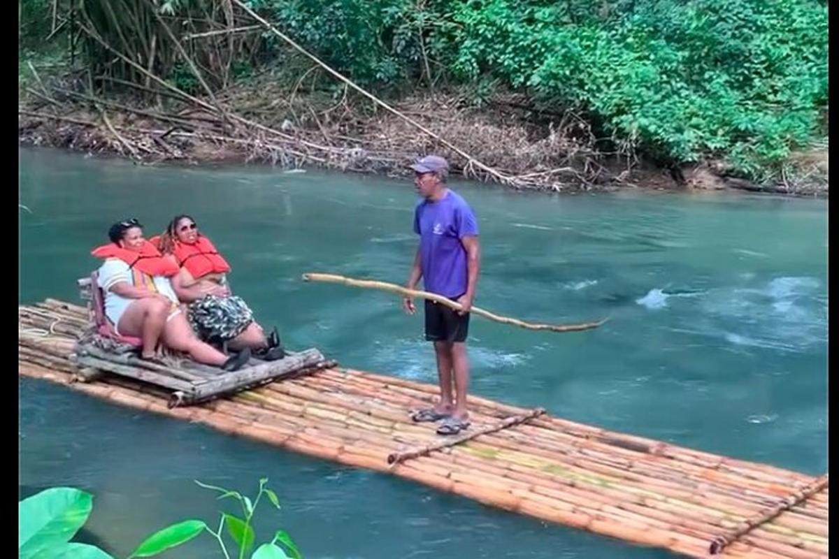 a man standing on a bamboo raft on a river