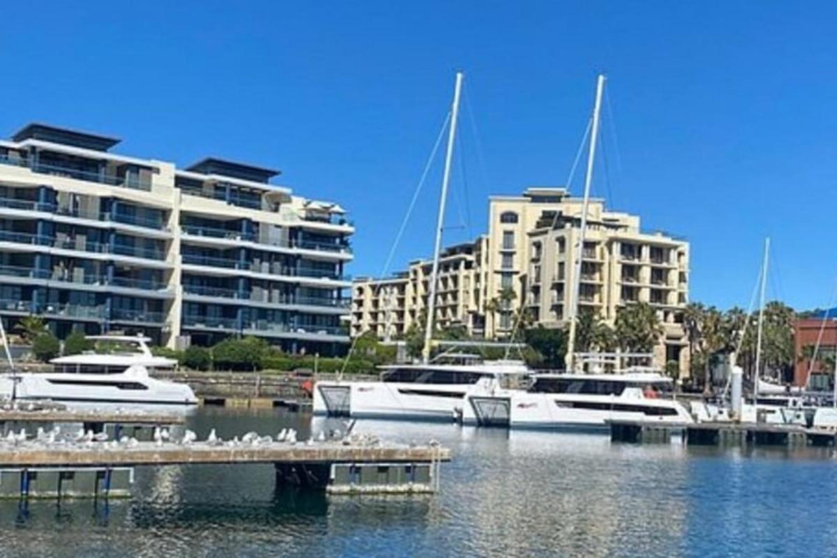 un gruppo di barche attraccate in un porto turistico con edifici