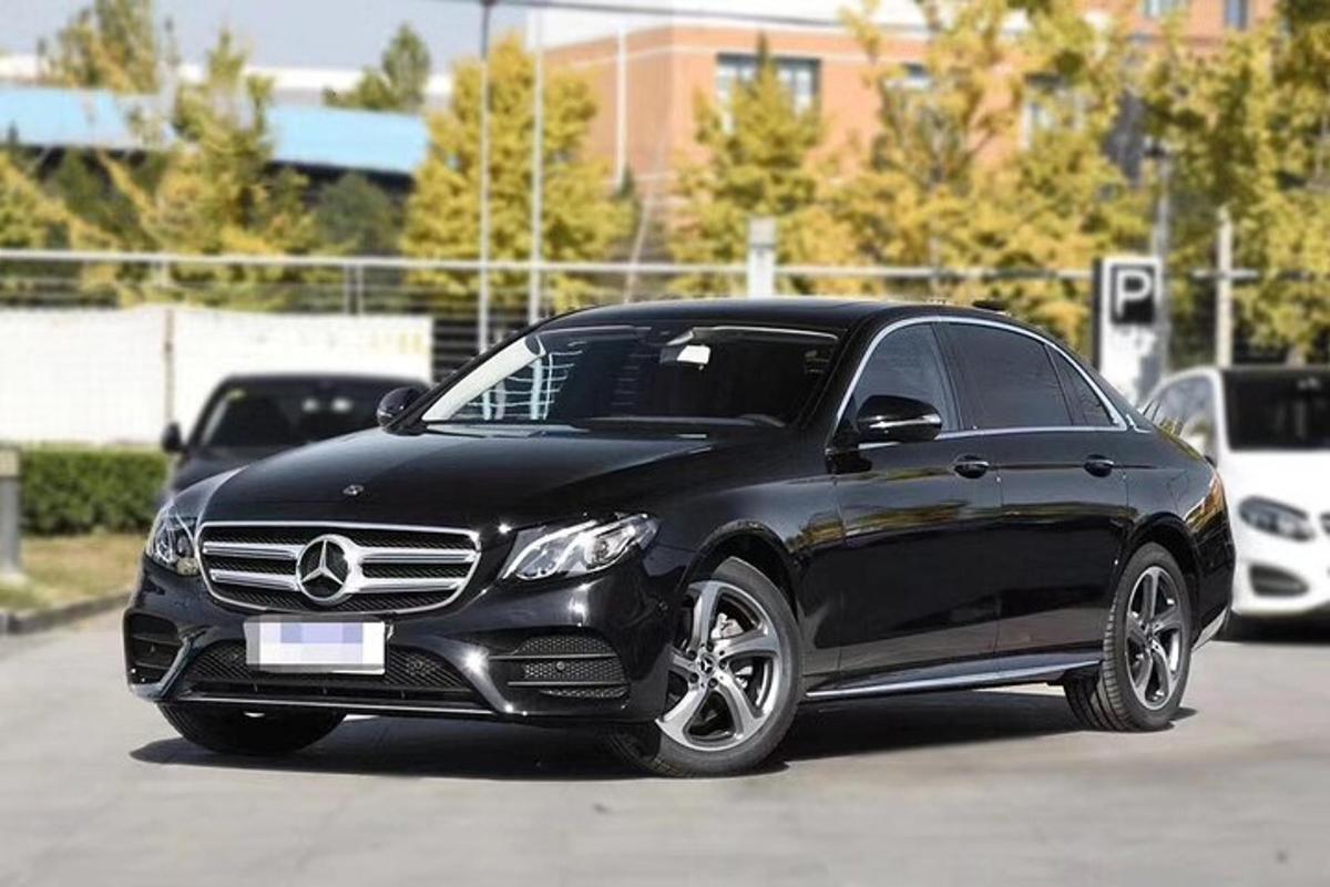 Un automóvil Mercedes Benz negro estacionado en un estacionamiento.