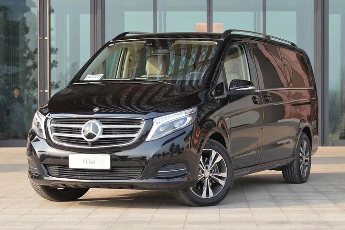 isang silver mercedes benz minivan ang nakaparada sa isang building