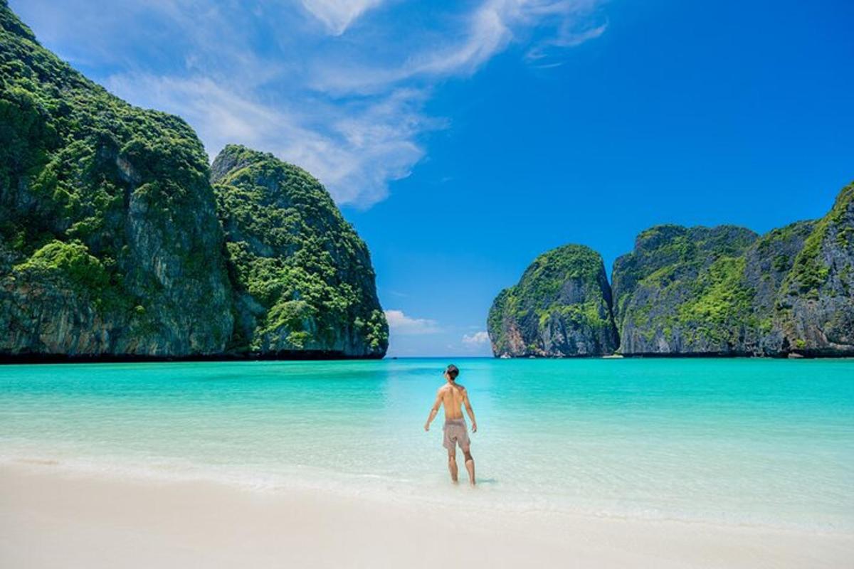 seorang lelaki berdiri di pantai di lautan