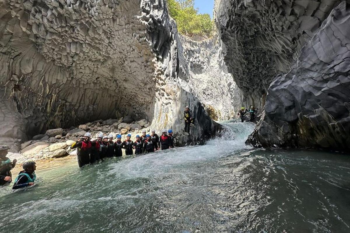 en gruppe mennesker som står i vannet i en canyon
