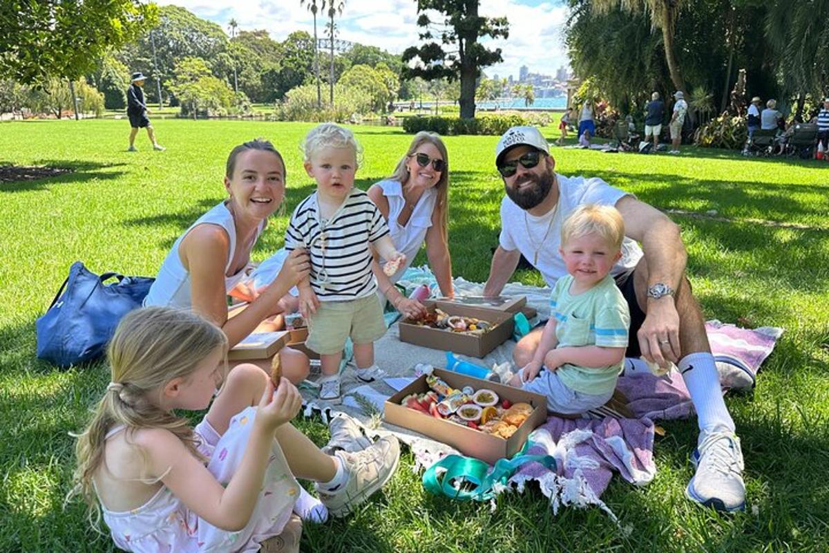 eine Familie sitzt auf dem Gras in einem Park