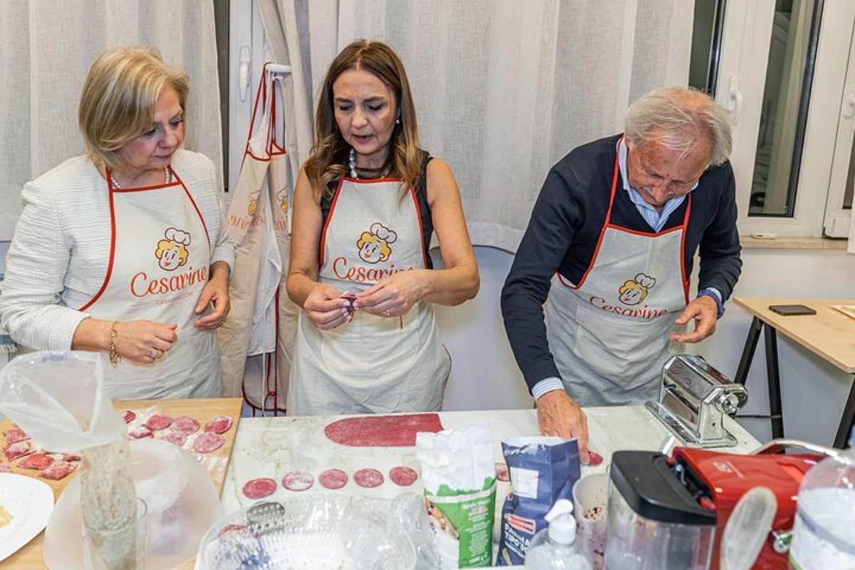 un uomo e due donne in una cucina che preparano il cibo