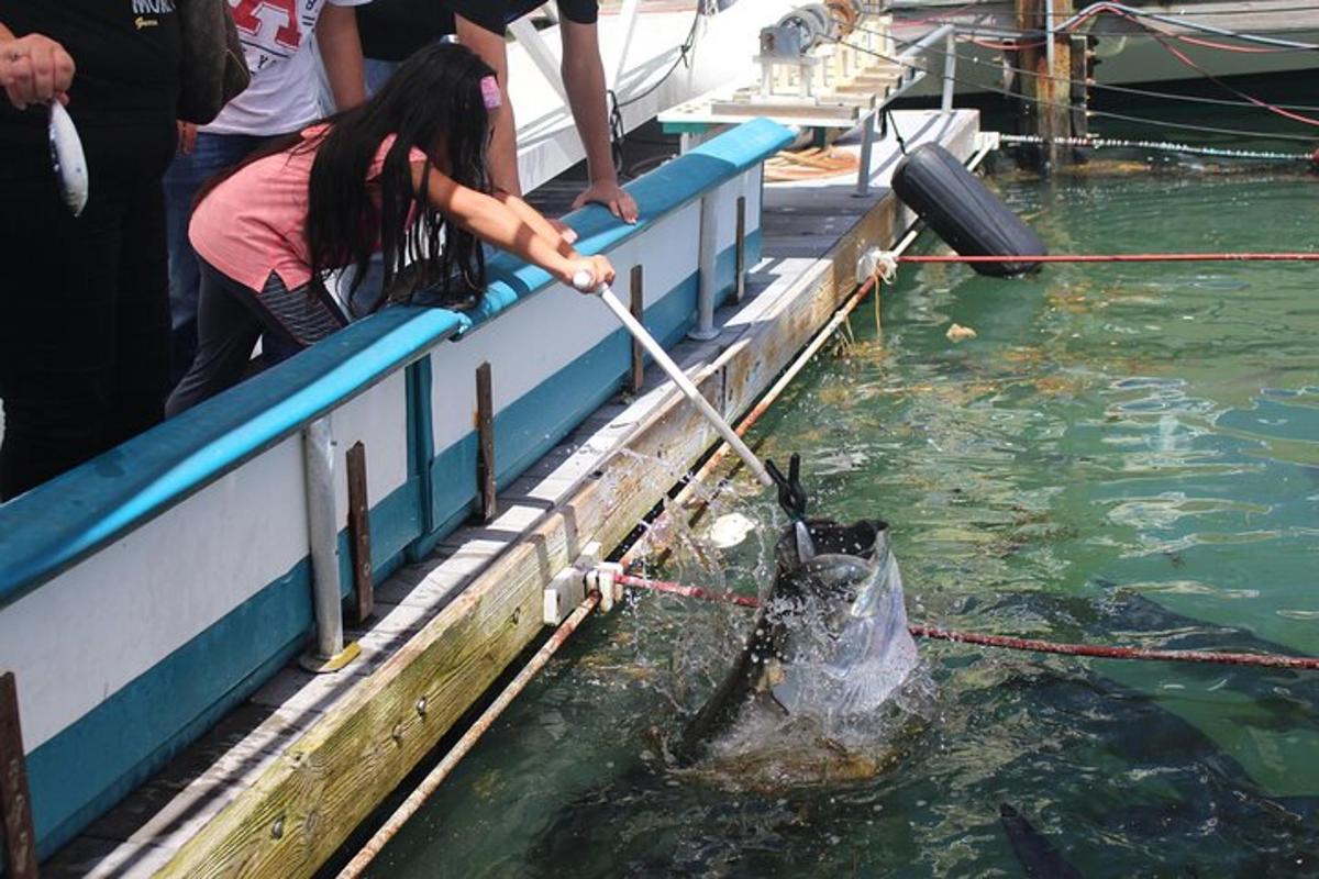 uma mulher está tirando um peixe da água