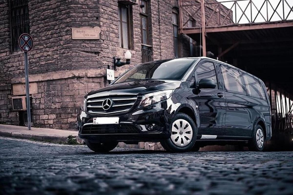 un'auto nera parcheggiata sul ciglio di una strada