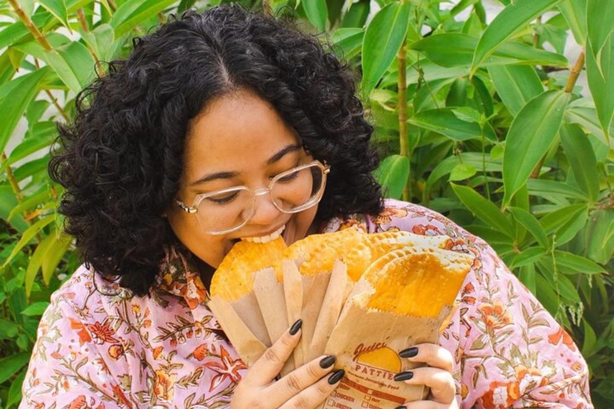 uma mulher de óculos comendo um sanduíche