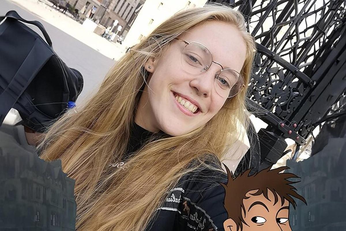 Mladá žena s brýlemi se usmívá do kamery