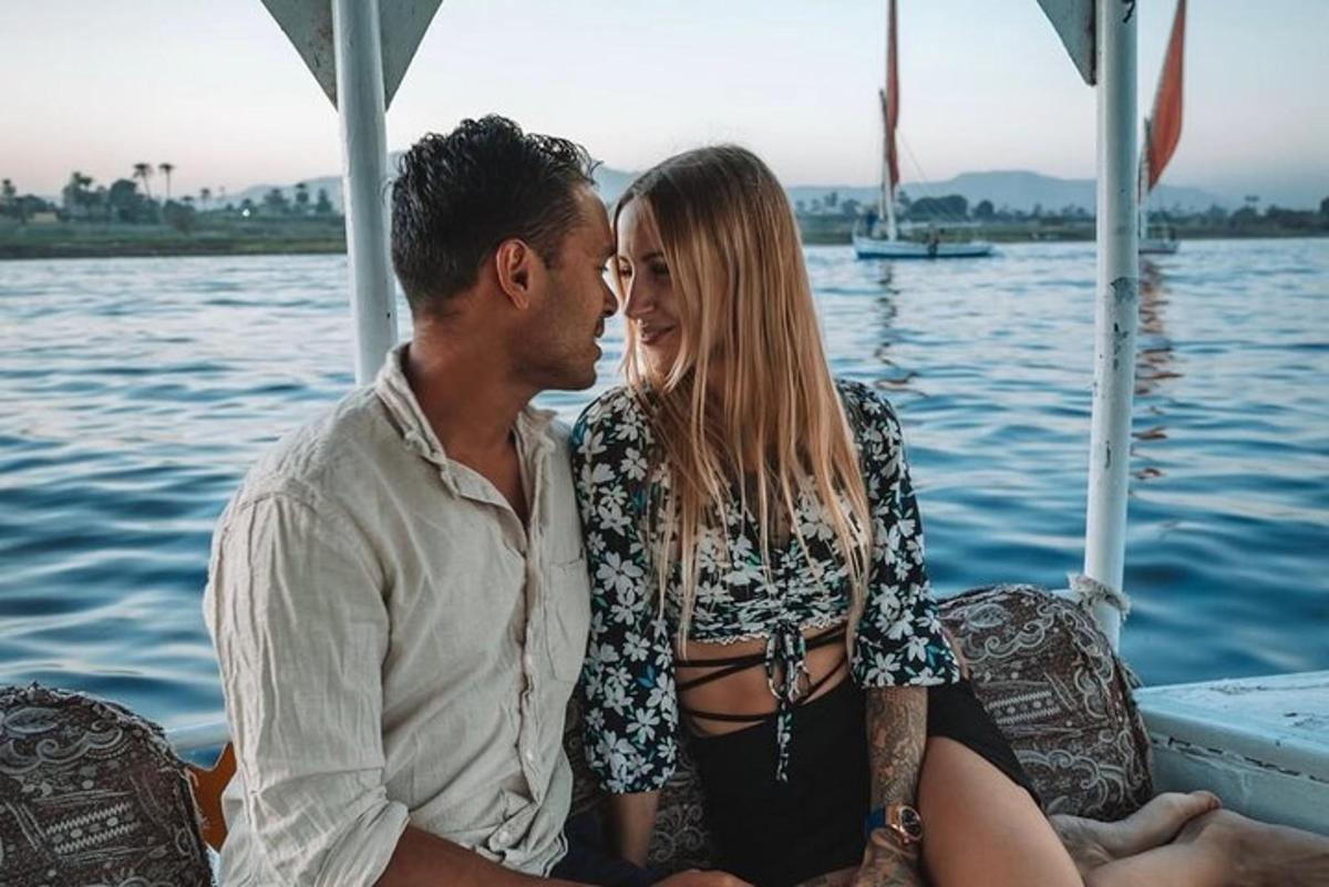 a man and woman sitting on a boat on the water