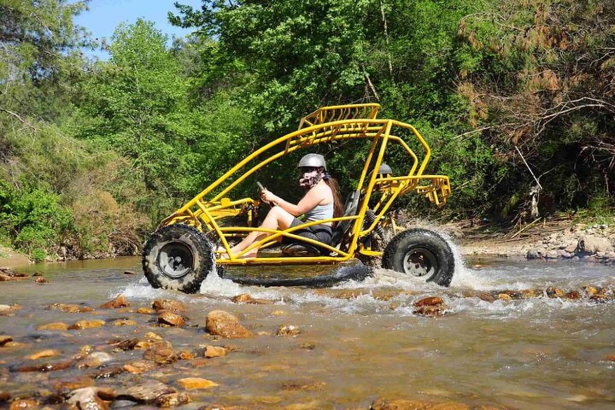 una persona su un quad giallo che attraversa un fiume