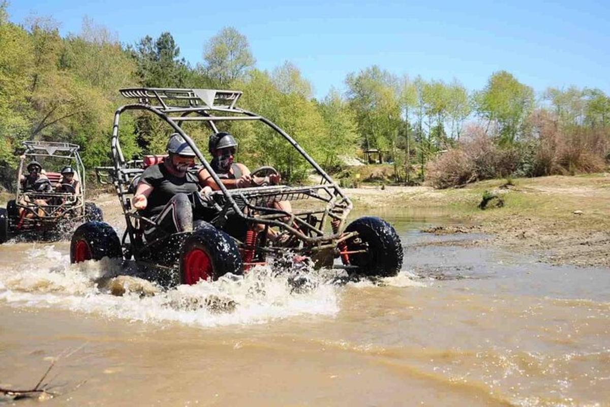 due persone che viaggiano su un veicolo a quattro ruote attraverso l'acqua