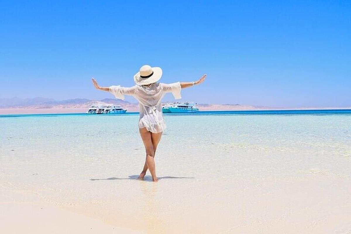 žena stoji na plaži s raširenim rukama