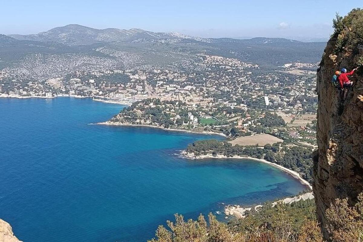 una persona parada en lo alto de un acantilado con vistas a una playa