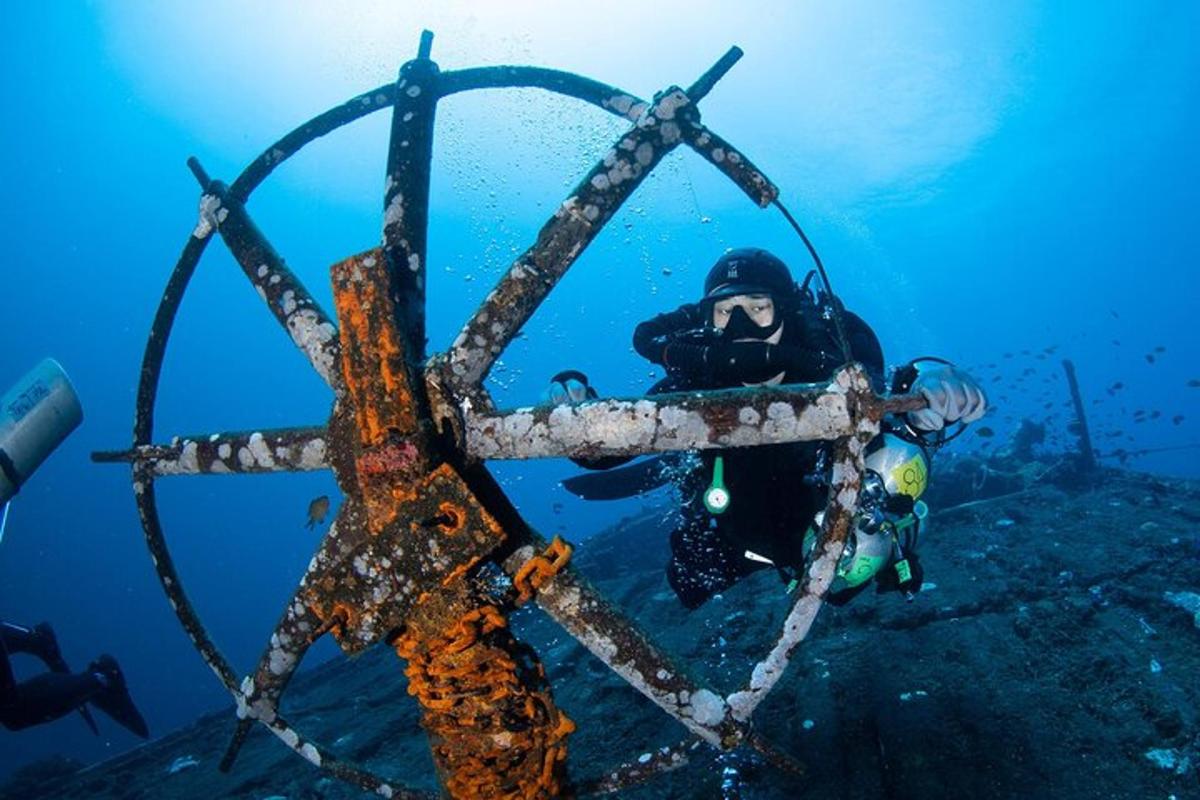 a diver in the ocean looking at a piece of a structure in the water