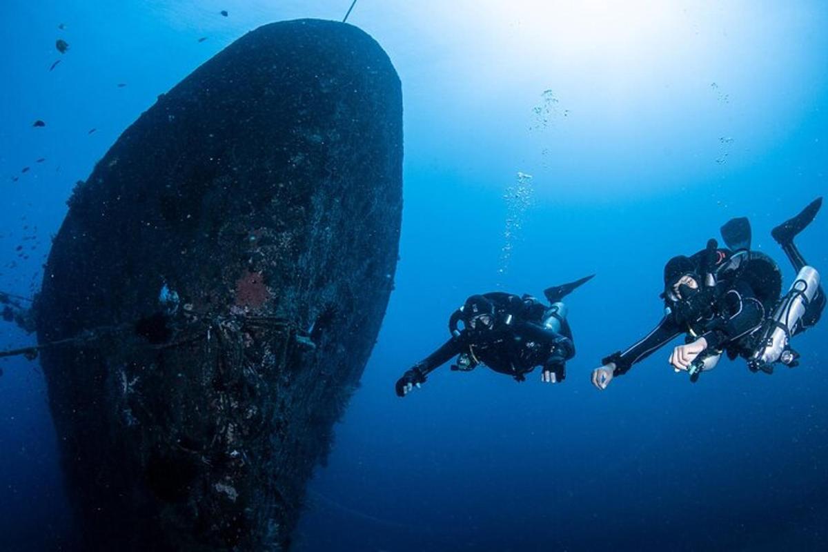 two people swimming in the ocean with a surfboard