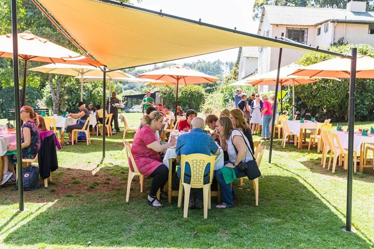 um grupo de pessoas sentadas em mesas sob uma tenda