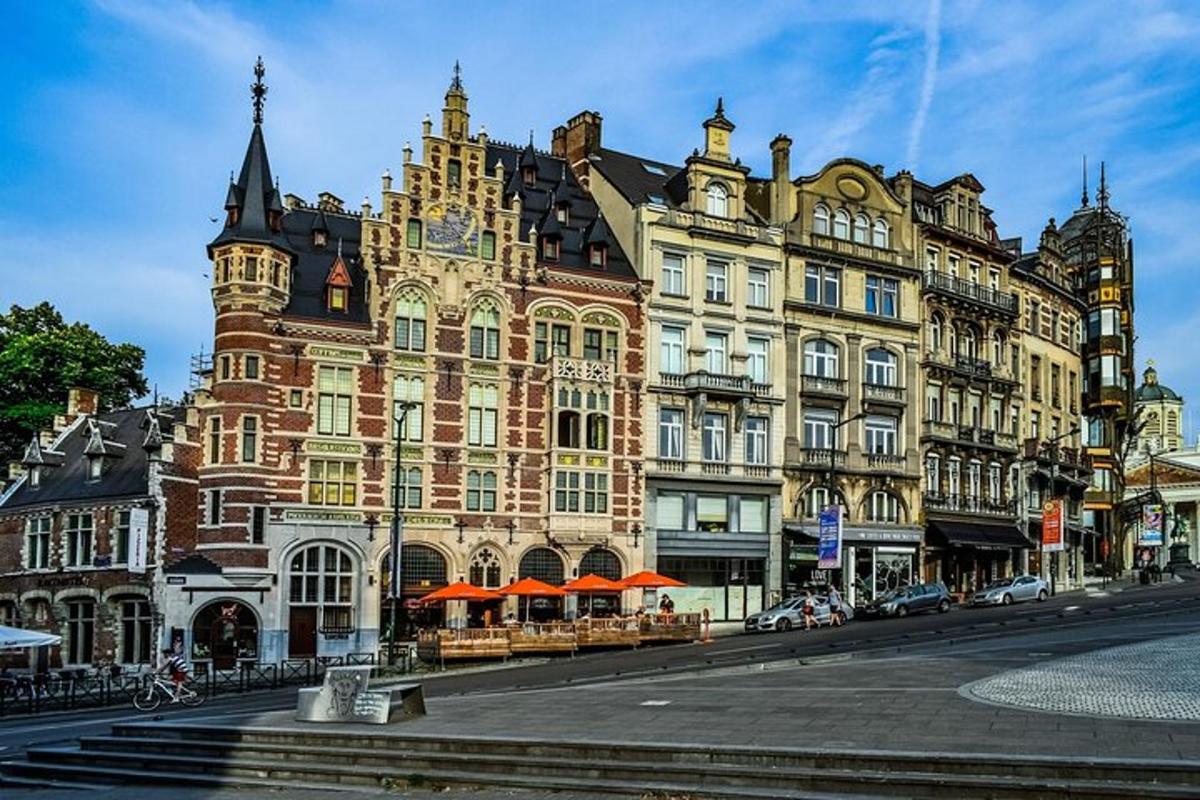 egy nagy téglaépület narancssárga napernyőkkel az utcán