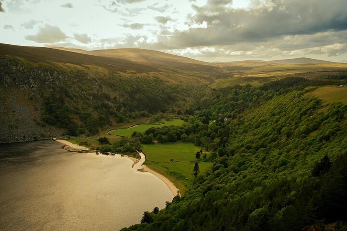 an aerial view of a river with trees and mountains