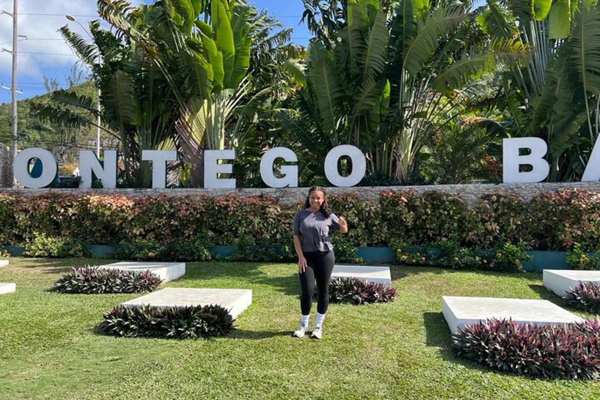 a woman standing in the grass in front of a sign
