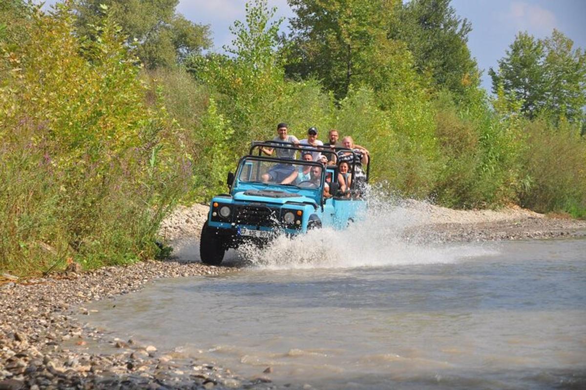 a group of people riding on the back of a truck in the water