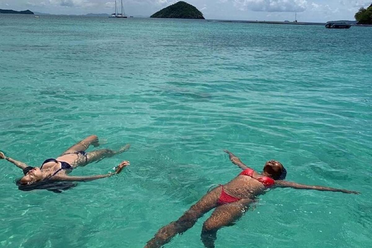 tři lidé ležící ve vodě v oceánu