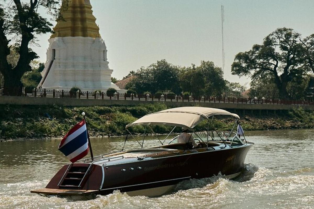 ein Boot mit einer Flagge im Wasser mit einem Tempel