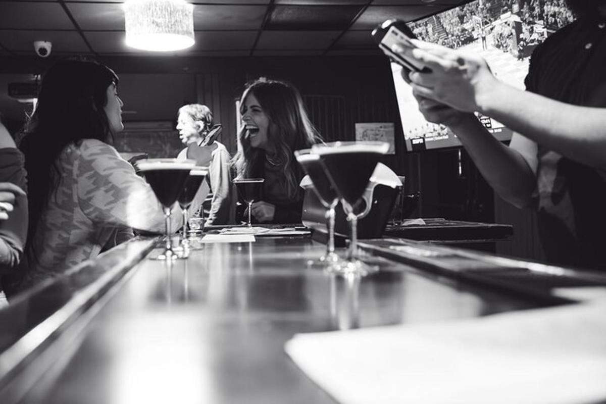 a group of people sitting at a bar with wine glasses