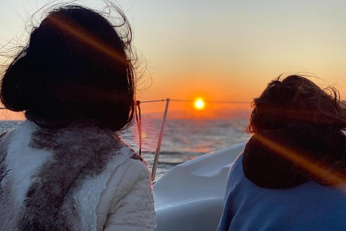 Dos mujeres en un barco mirando la puesta de sol