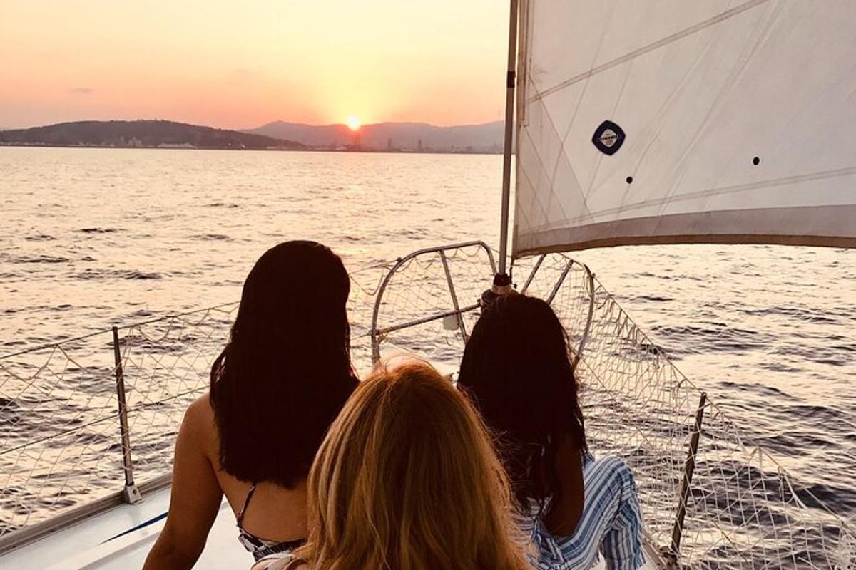 Tres mujeres sentadas en un barco mirando la puesta de sol