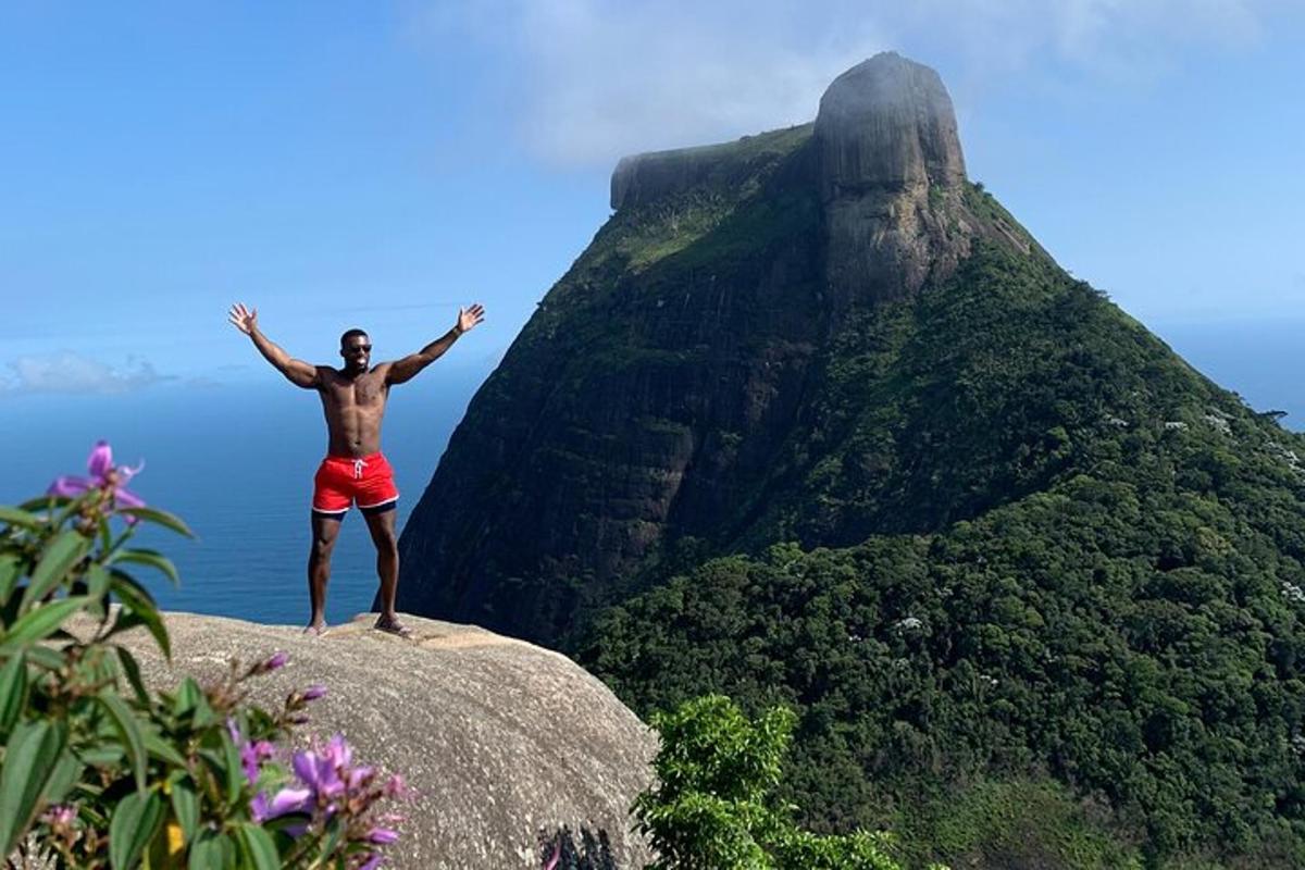a man standing on a rock with his arms up