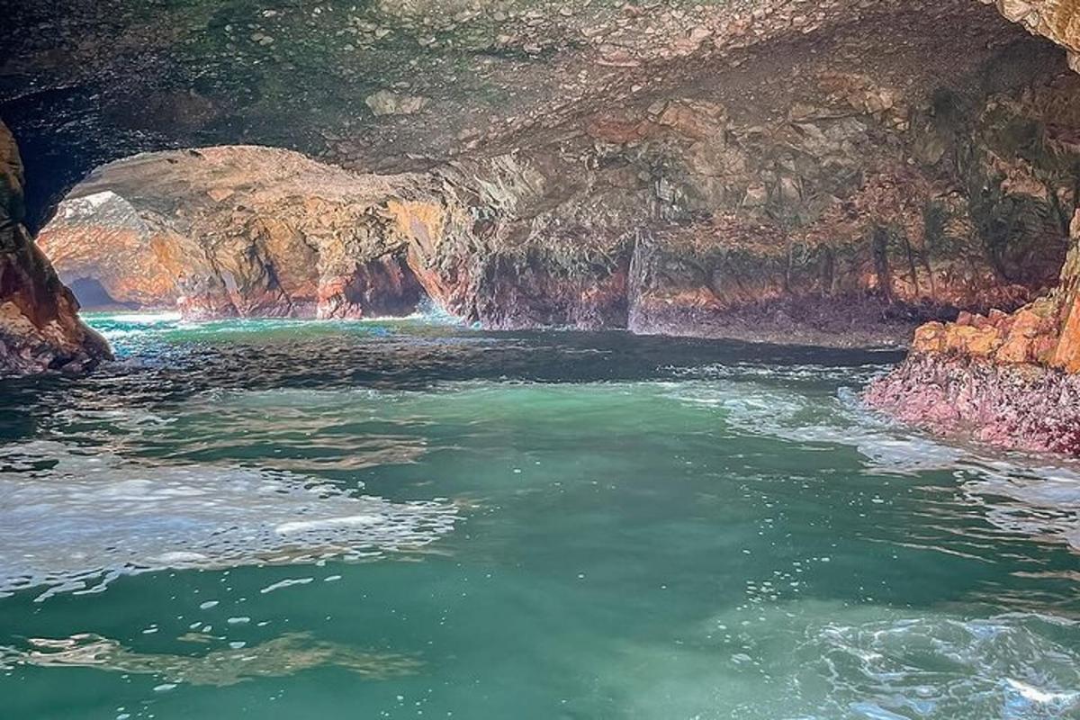 un bassal d'aigua en una cova amb una cascada