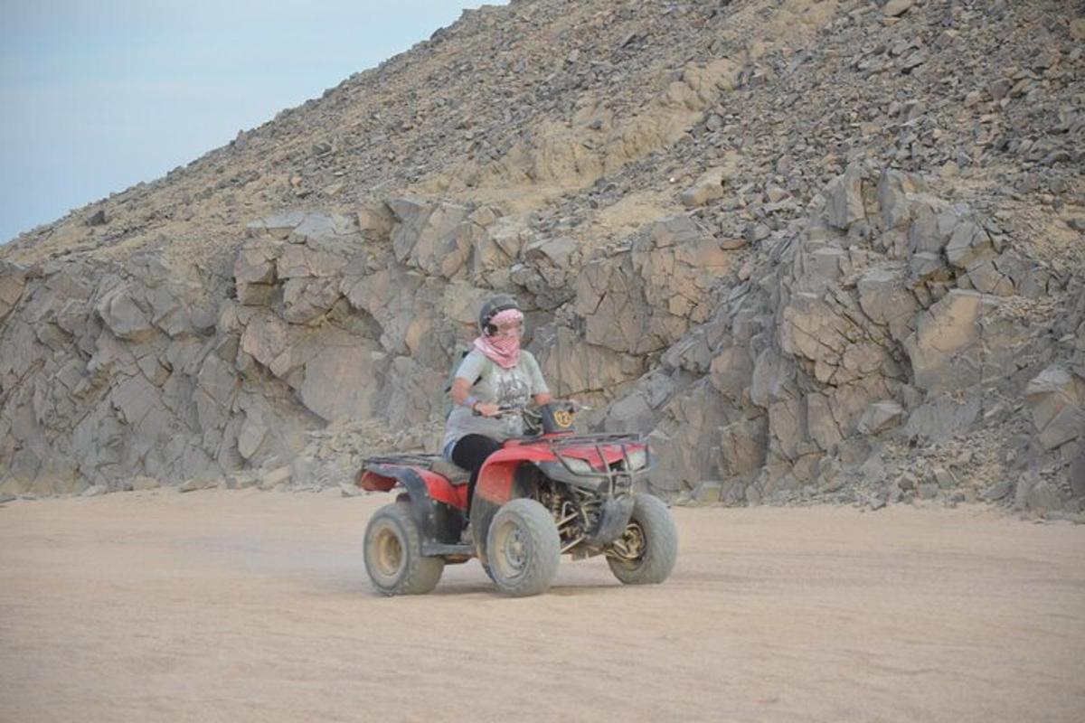una persona che guida un quad nel deserto