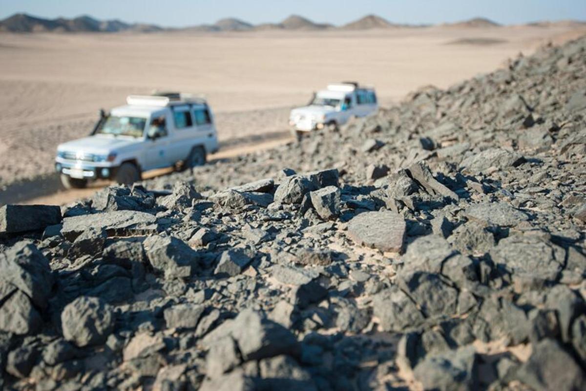 due veicoli che guidano su una strada rocciosa nel deserto