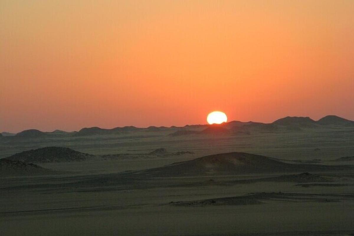 un tramonto nel deserto con le montagne sullo sfondo