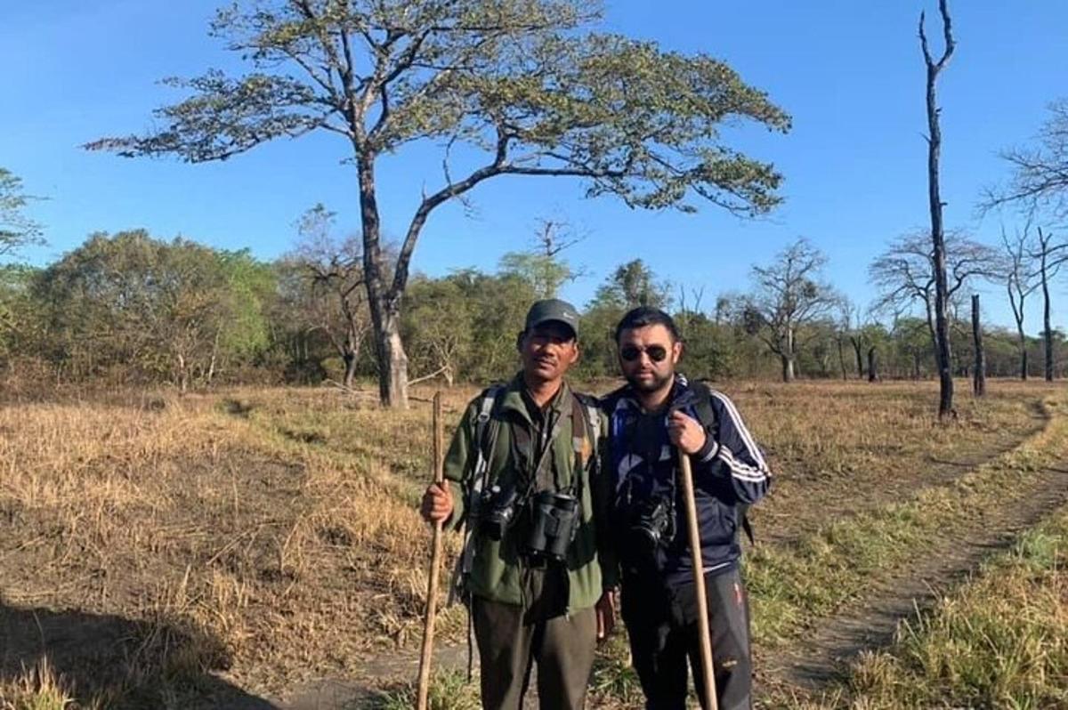 two men are posing for a picture on a dirt road