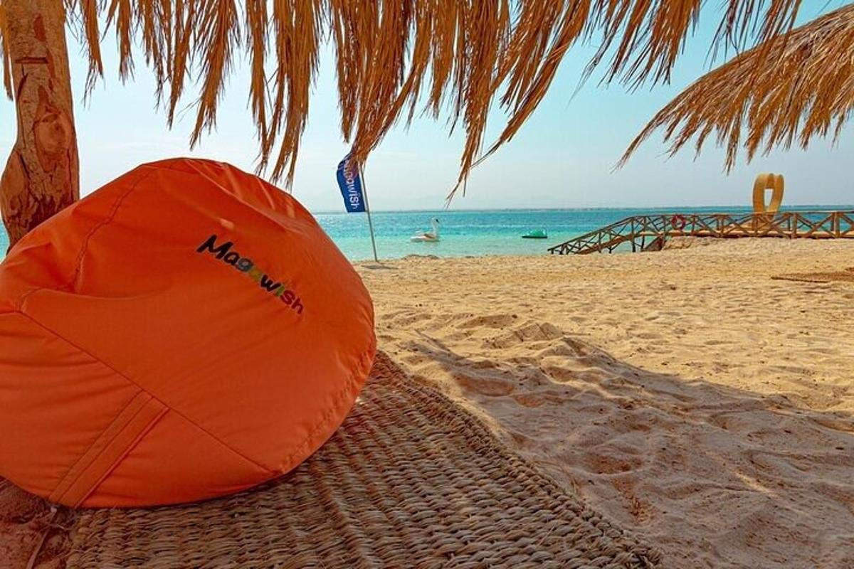 oranžen dežnik na peščeni plaži