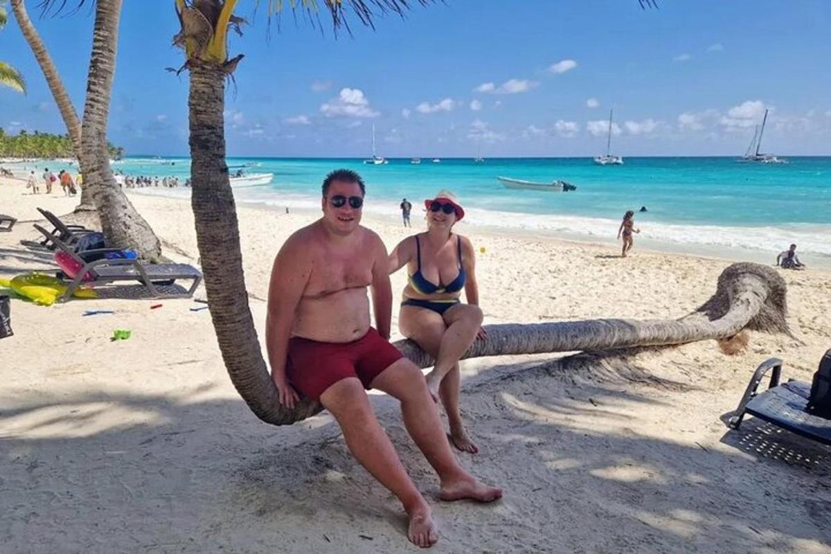 a man and a woman sitting on a hammock on a beach