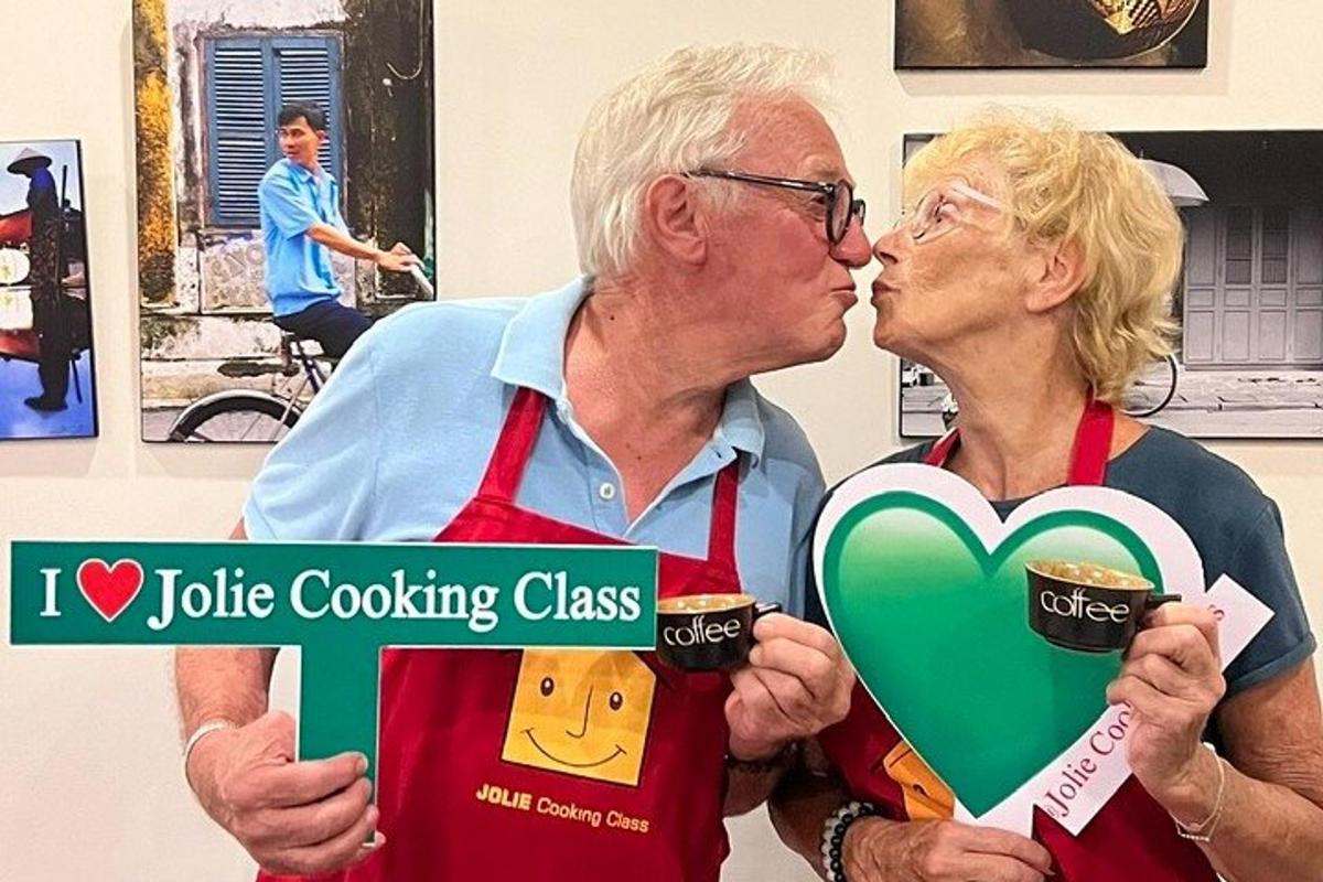 Muž a žena drží ceduli s nápisem „I'm a course of turtle cooking“ (Kurz vaření želv)