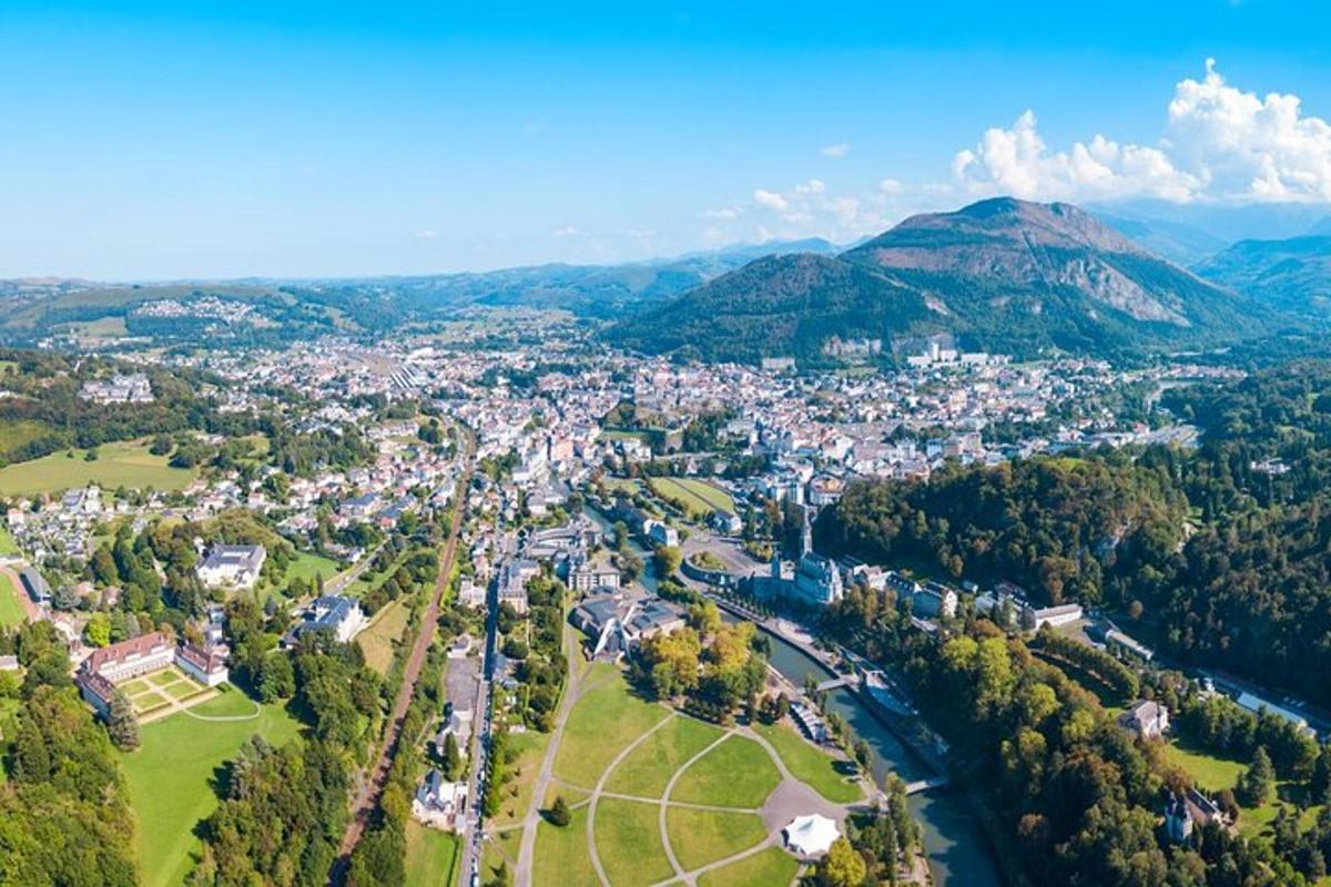 an aerial view of a city with a river and mountains