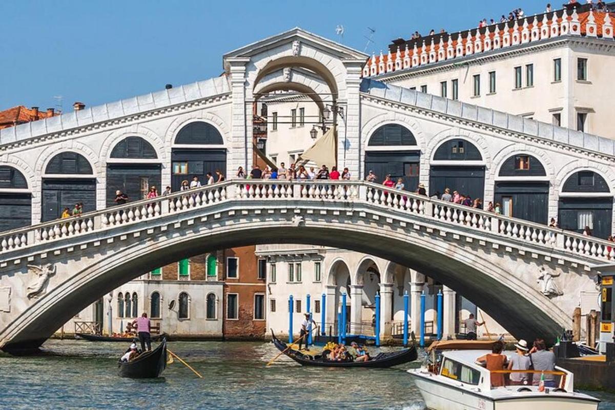 un pont sur une rivière avec des gondoles dans l'eau